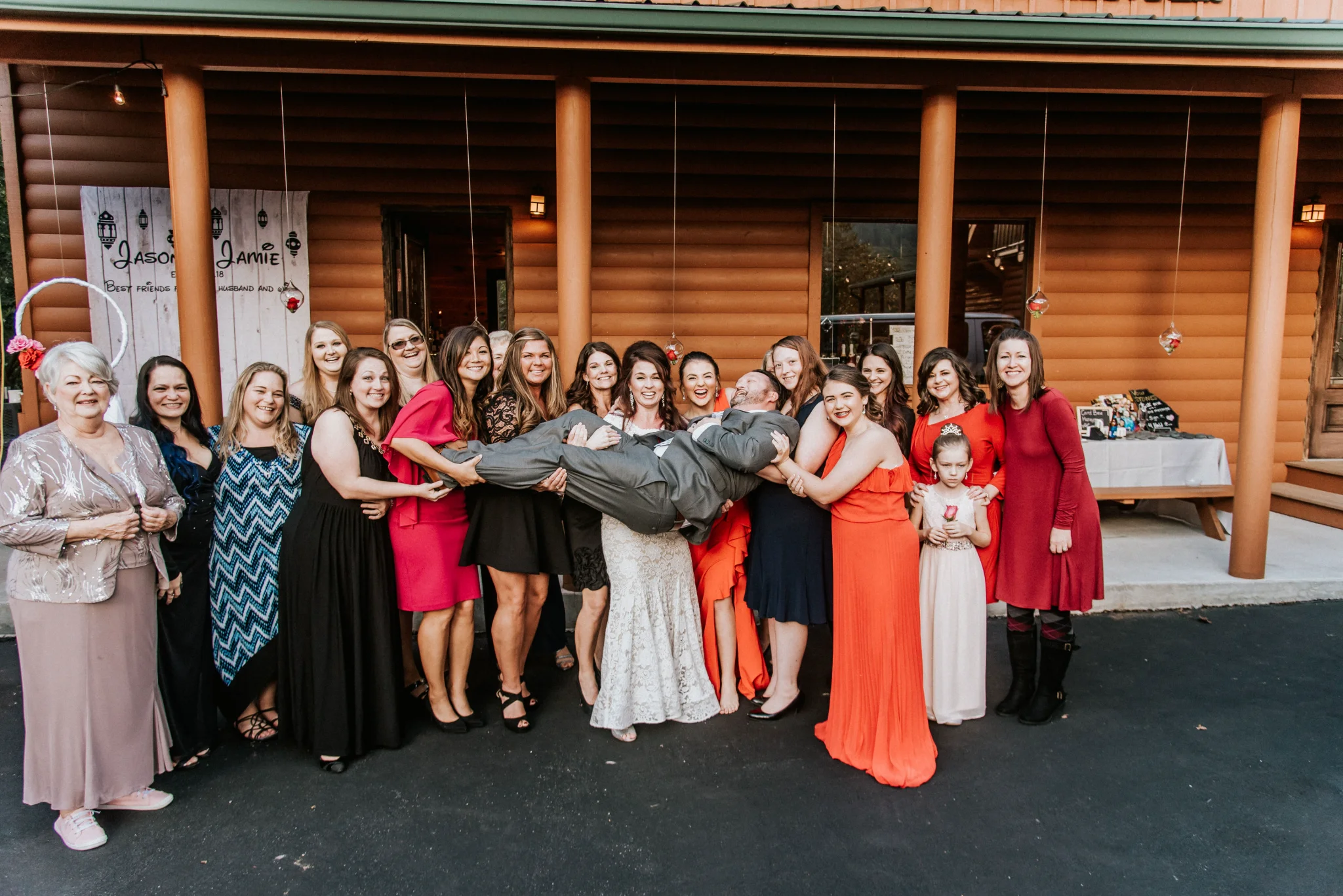 Wedding party lifting groom outside rustic lodge at Moose Hollow Lodge in Pigeon Forge near Dollywood and Smoky Mountains