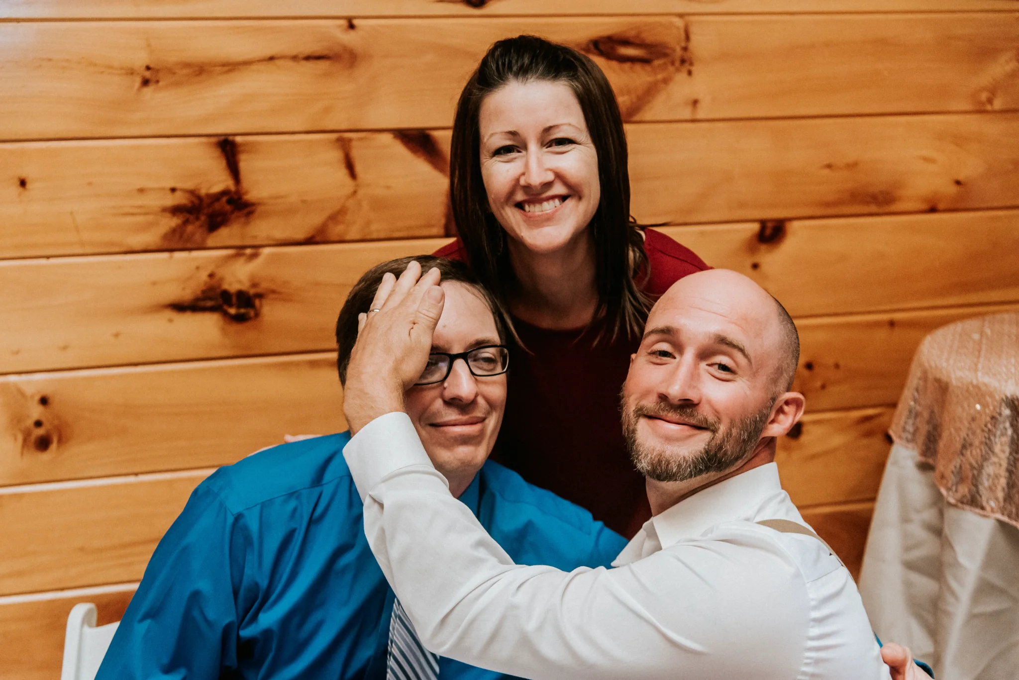 Smiling wedding guests in rustic wood-paneled reception hall at Moose Hollow Lodge in Pigeon Forge