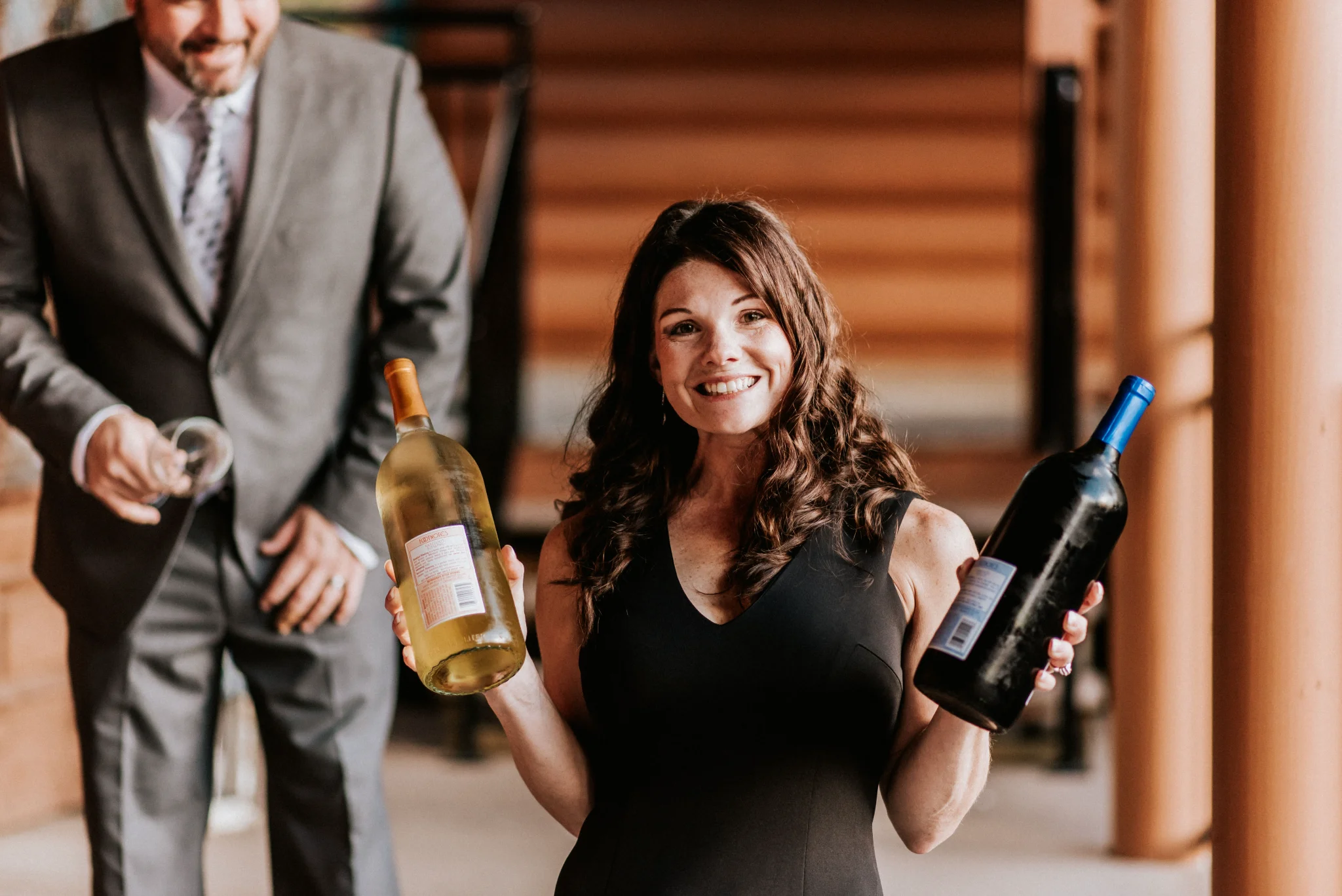 Smiling woman holding wine bottles on a lodge deck at Moose Hollow Lodge in Pigeon Forge near Smoky Mountains