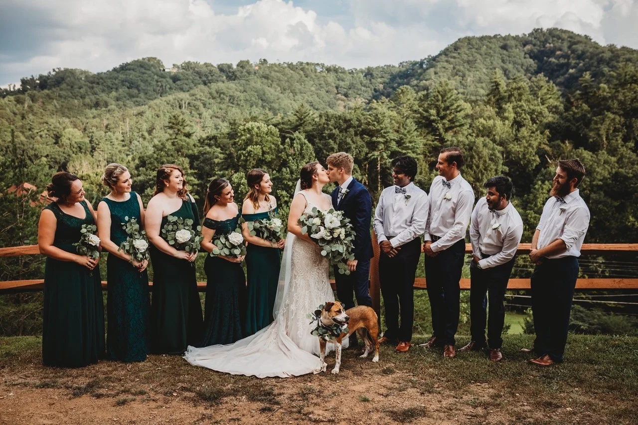 Bride and groom kissing with wedding party and Smoky Mountain views at Moose Hollow Lodge in Pigeon Forge near Dollywood
