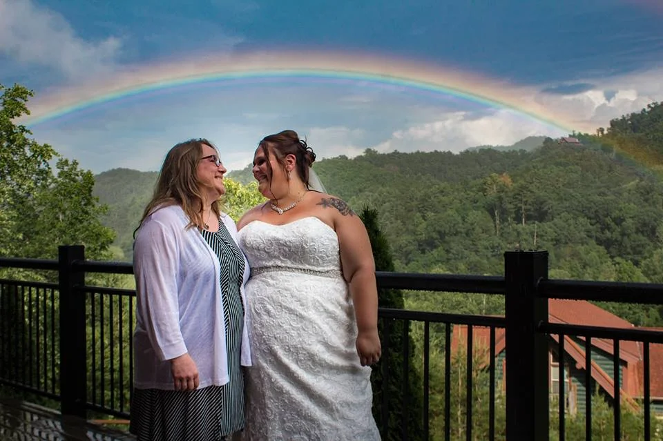 Bride on deck with a rainbow and Smoky Mountain views at Moose Hollow Lodge in Pigeon Forge near Dollywood