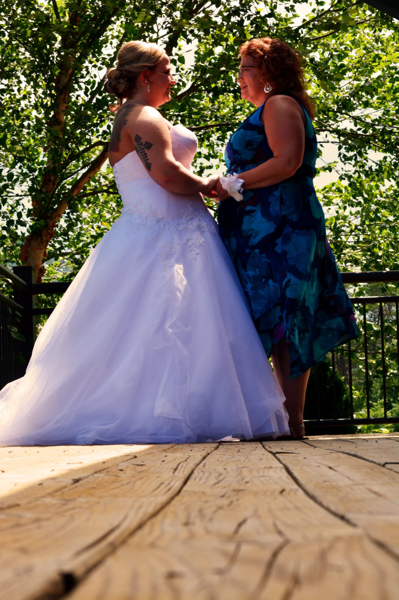 Bride and guest holding hands on outdoor deck with forest views at Moose Hollow Lodge near Dollywood in Pigeon Forge