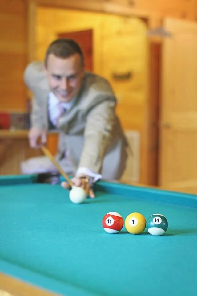 Groom playing billiards in the game room at Moose Hollow Lodge in Pigeon Forge