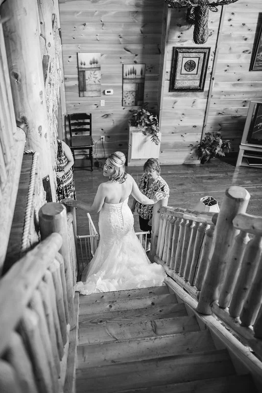 Bride descending rustic log staircase inside lodge at Moose Hollow Lodge in Pigeon Forge