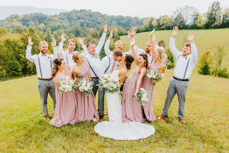 Wedding party poses in a field, bride and groom kiss, bridesmaids in rose dresses, groomsmen in grey pants. Moose Hollow...